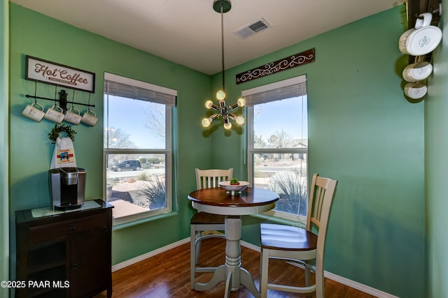 dining room with visible vents, baseboards, a notable chandelier, and dark wood-style flooring