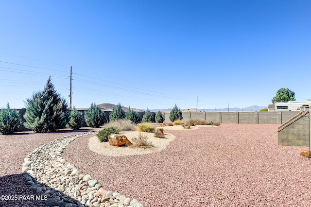 view of yard featuring a mountain view and fence