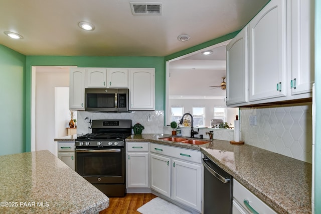 kitchen featuring white cabinets, visible vents, appliances with stainless steel finishes, and a sink