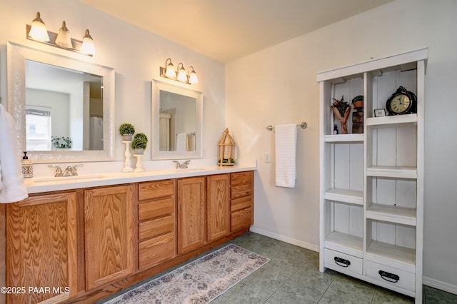 bathroom featuring a sink, baseboards, double vanity, and tile patterned floors