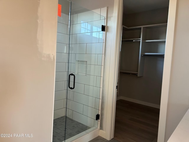 bathroom with hardwood / wood-style floors and a shower with door