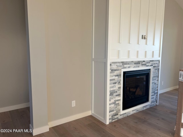 interior details with a stone fireplace and wood-type flooring