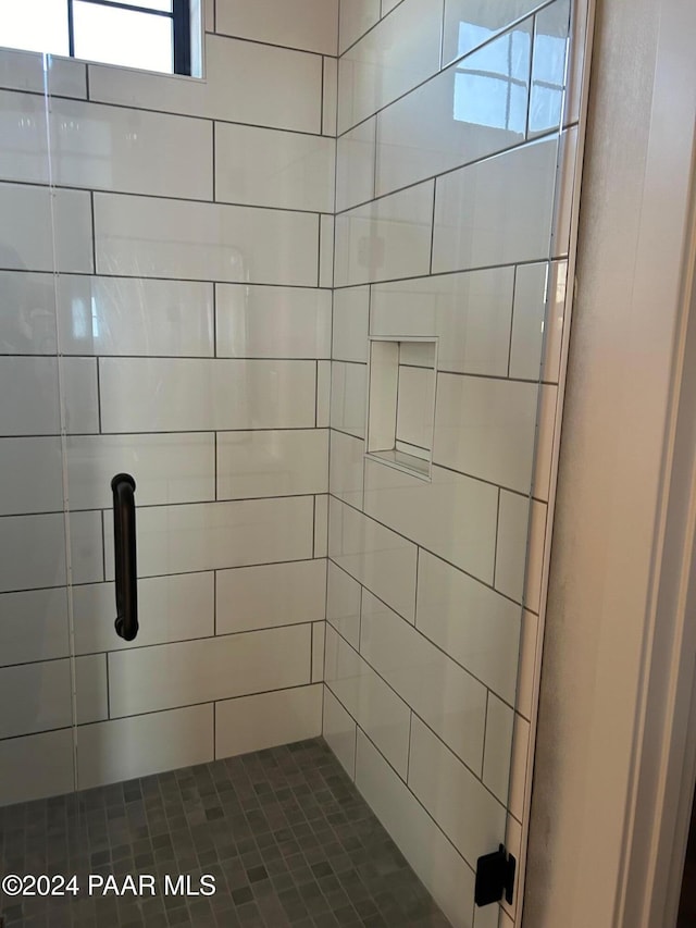 bathroom featuring a shower with door