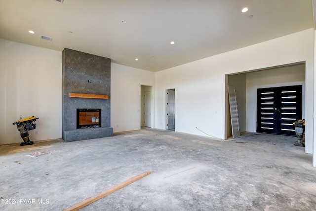 unfurnished living room featuring a large fireplace and concrete floors