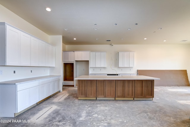 kitchen featuring white cabinets and a kitchen island with sink