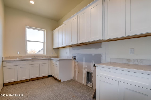 laundry room with cabinets and sink