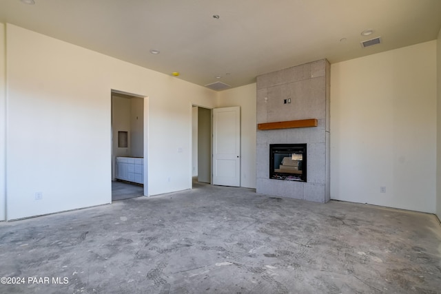 unfurnished living room with a tiled fireplace