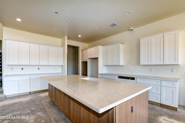 kitchen featuring white cabinetry, a center island, and light stone counters