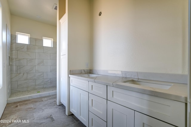 bathroom featuring a tile shower and vanity