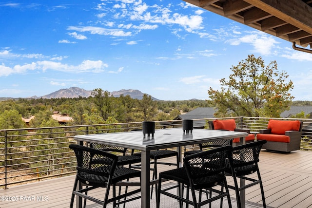 wooden deck with a wooded view and a mountain view