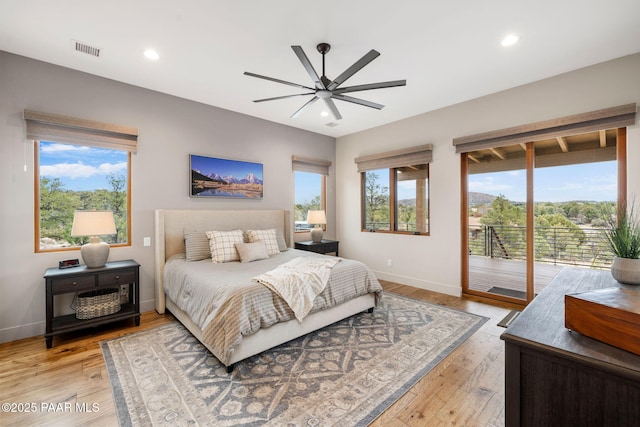 bedroom featuring visible vents, light wood-style flooring, baseboards, and access to outside