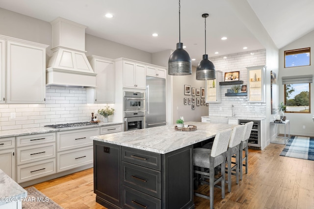 kitchen featuring white cabinetry, beverage cooler, dark cabinets, and stainless steel appliances