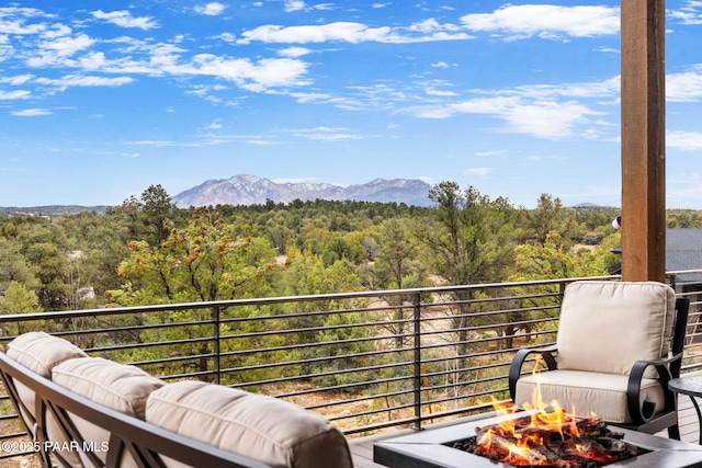 balcony featuring a mountain view, a forest view, and an outdoor living space with a fire pit