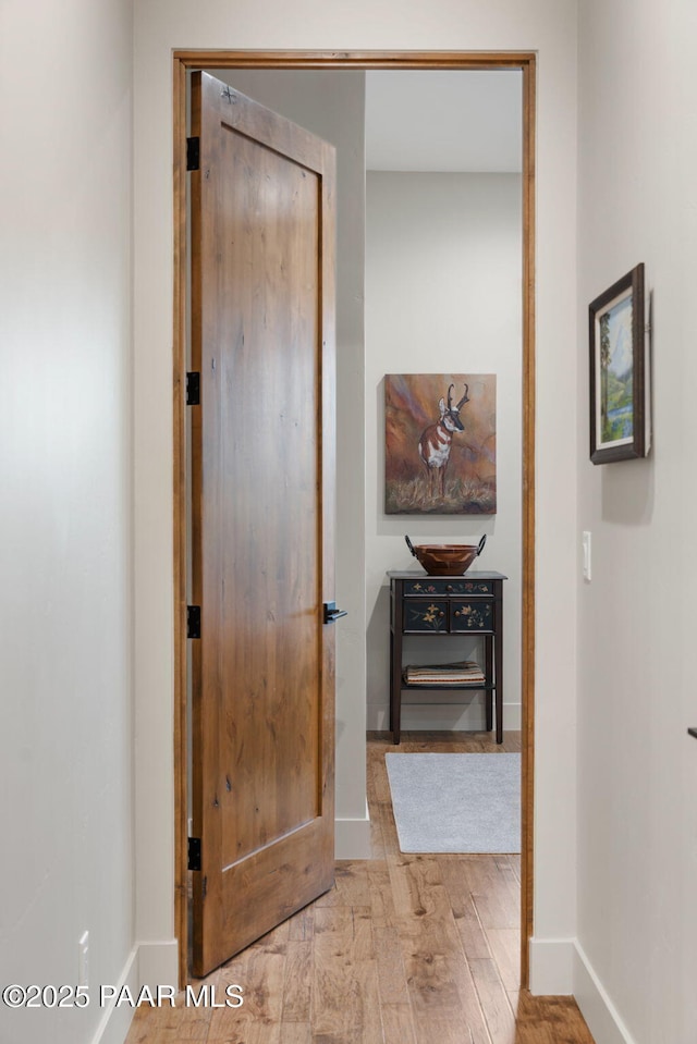 hall with wood finished floors and baseboards