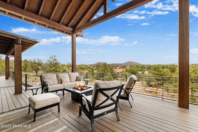 wooden terrace featuring an outdoor living space with a fire pit and a mountain view