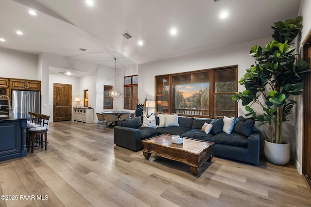 living room featuring light wood-type flooring and sink