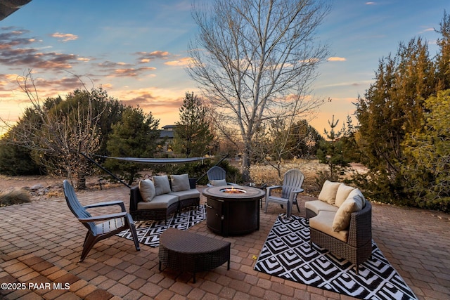 patio terrace at dusk with an outdoor living space with a fire pit