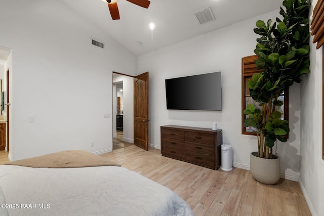 bedroom with light wood-type flooring, ceiling fan, lofted ceiling, and connected bathroom