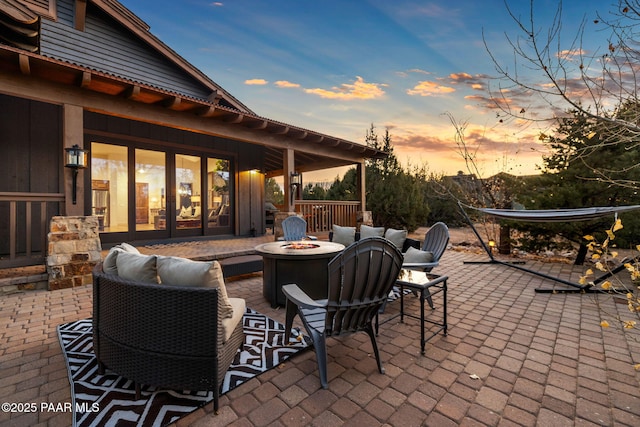 patio terrace at dusk with an outdoor living space with a fire pit