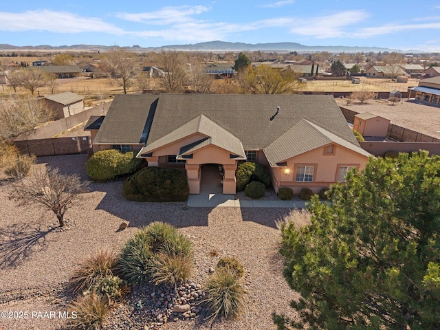 view of front facade featuring a residential view, stucco siding, and a mountain view