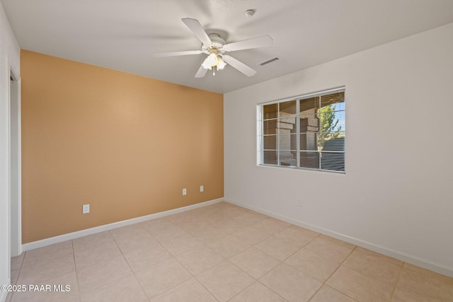 spare room featuring light tile patterned floors, visible vents, baseboards, and ceiling fan