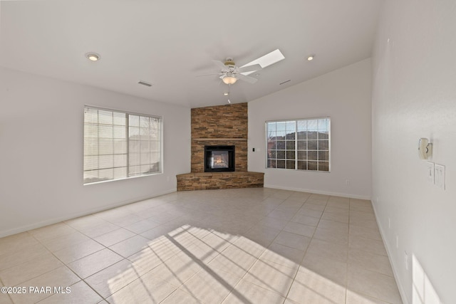 unfurnished living room featuring light tile patterned floors, a healthy amount of sunlight, a fireplace, and ceiling fan