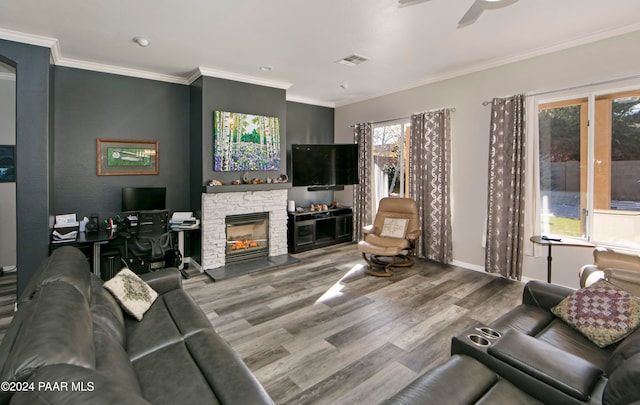 living room with a fireplace, light hardwood / wood-style floors, ceiling fan, and ornamental molding