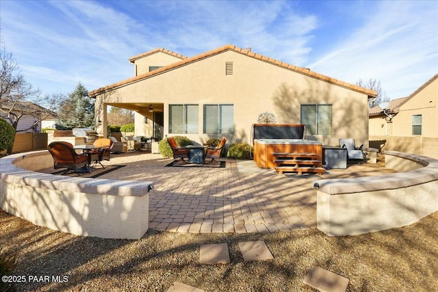 back of property featuring an outdoor hangout area, a hot tub, and a patio