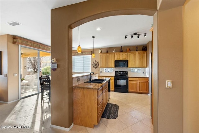 kitchen with sink, light stone counters, light tile patterned floors, pendant lighting, and black appliances