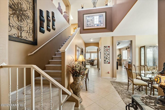 entrance foyer with light tile patterned flooring and a towering ceiling