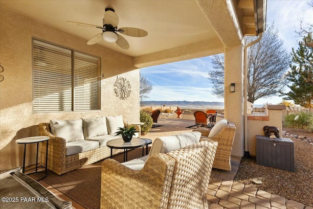 view of patio / terrace featuring ceiling fan, an outdoor hangout area, and a mountain view