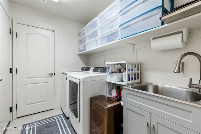 washroom featuring cabinets, washing machine and dryer, sink, and light tile patterned flooring