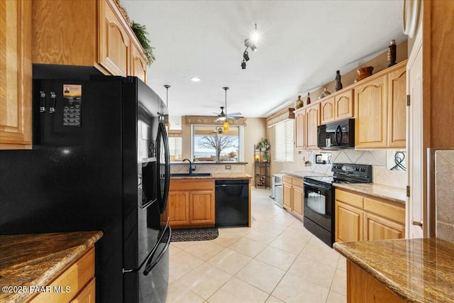 kitchen with light tile patterned flooring, light stone counters, hanging light fixtures, decorative backsplash, and black appliances