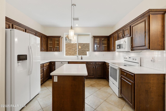 7070 E Lantern Ln, Prescott Valley, AZ 86314 - kitchen featuring white appliances, backsplash, light countertops, a kitchen island, and pendant lighting