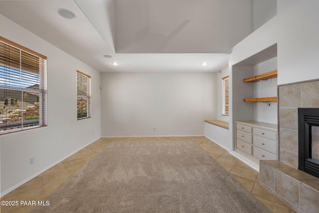 7070 E Lantern Ln, Prescott Valley, AZ 86314 - unfurnished living room featuring a tiled fireplace, light tile patterned floors, plenty of natural light, and recessed lighting