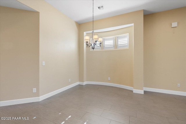 spare room with an inviting chandelier