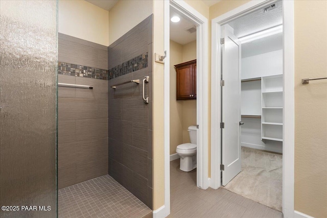 bathroom featuring toilet and tiled shower