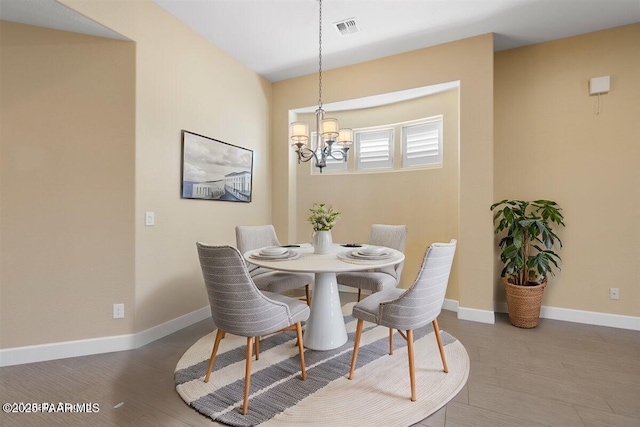 dining room with hardwood / wood-style flooring and a notable chandelier