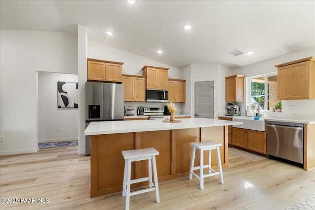 4956 E Ramada Dr, Prescott, AZ 86301 - kitchen with stainless steel appliances, light wood-type flooring, lofted ceiling, a center island, and light countertops