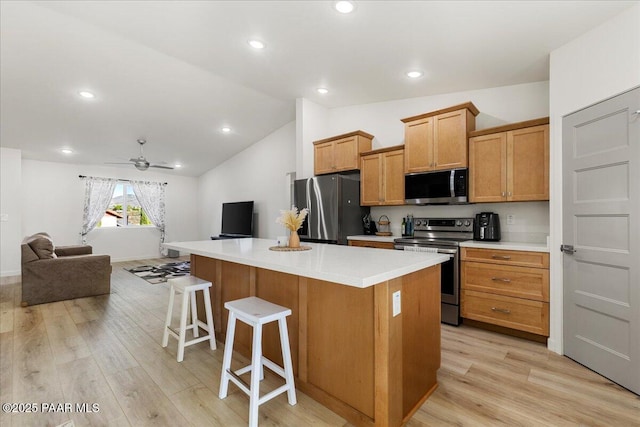4956 E Ramada Dr, Prescott, AZ 86301 - kitchen with stainless steel appliances, open floor plan, light wood-type flooring, a kitchen island, and a breakfast bar