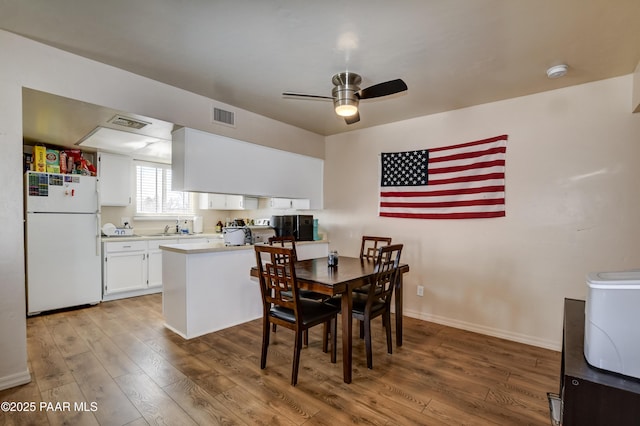 dining area with sink, dark hardwood / wood-style floors, and ceiling fan