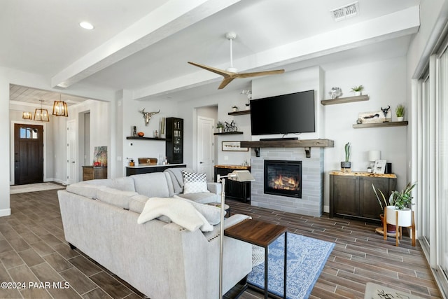 living room with beam ceiling, ceiling fan, and dark wood-type flooring