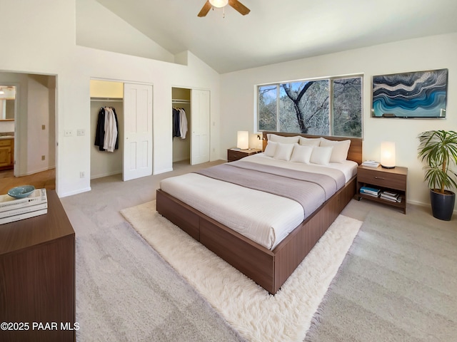 bedroom featuring baseboards, light colored carpet, ceiling fan, high vaulted ceiling, and multiple closets