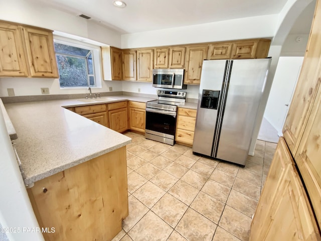 kitchen featuring light tile patterned floors, appliances with stainless steel finishes, a sink, and recessed lighting