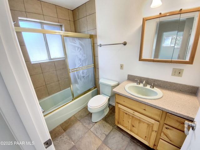 full bathroom featuring toilet, enclosed tub / shower combo, and vanity