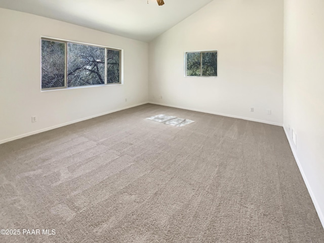 spare room with carpet flooring, vaulted ceiling, baseboards, and ceiling fan