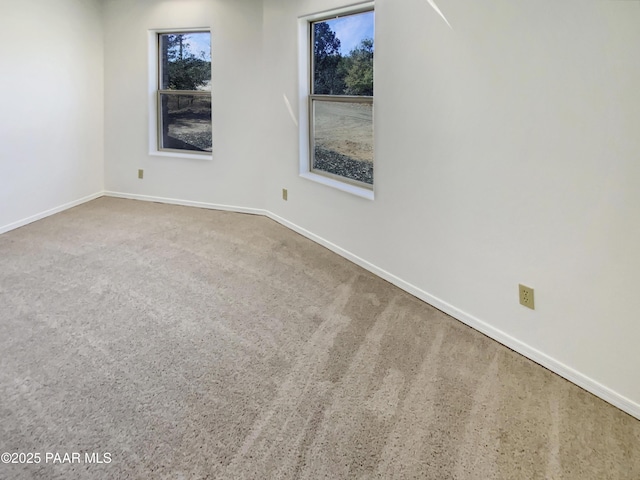 carpeted empty room with baseboards