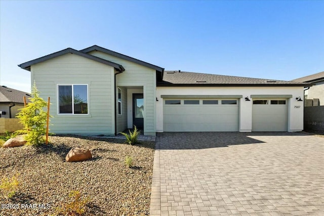 view of front of house with decorative driveway and an attached garage