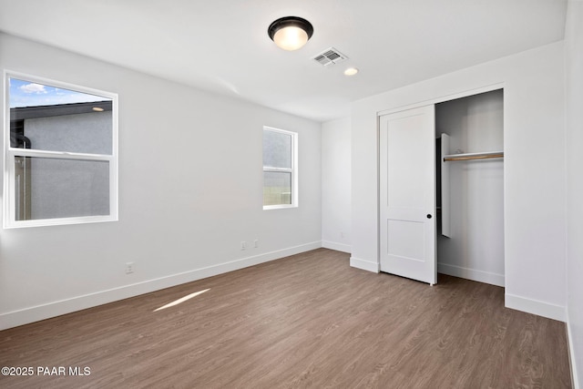 unfurnished bedroom featuring hardwood / wood-style flooring and a closet