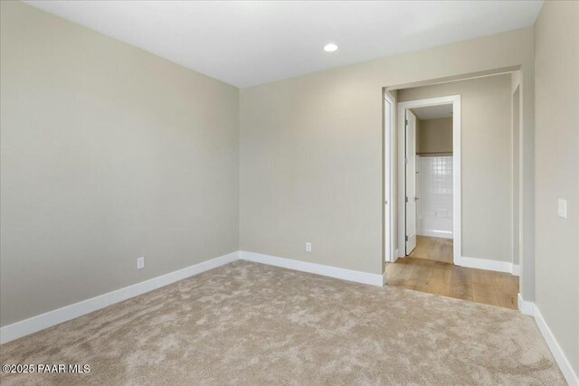 unfurnished bedroom with wood finished floors, baseboards, and visible vents
